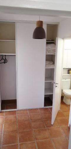 La salle de bains est pourvue d'un placard blanc et de toilettes. dans l'établissement Cambo Centre, commerces et nature à 5 min à pied et proche Thermes, à Cambo-les-Bains