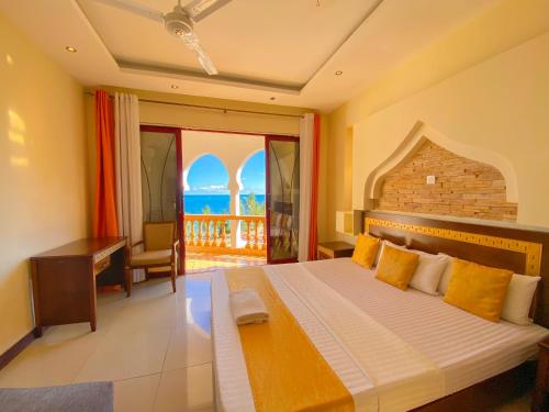 a bedroom with a bed with a view of the ocean at Shanzu Reef Beachfront Apartments in Mombasa