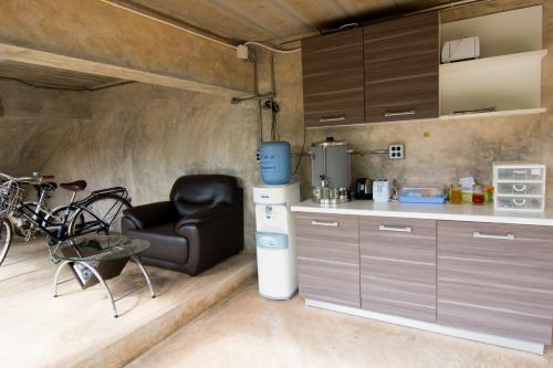 a kitchen with a chair and a table and a refrigerator at Sunee Boutique Hotel in Uttaradit