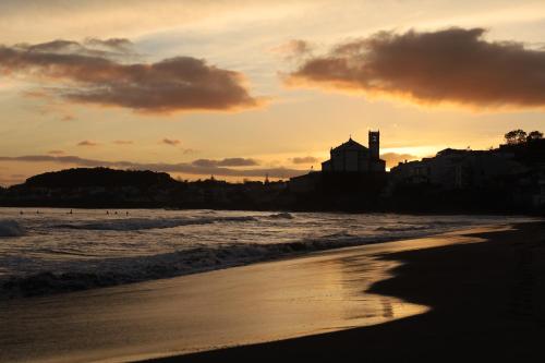 a person walking on the beach at sunset at R&M Place in São Roque
