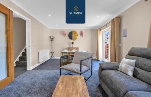 a living room with a couch and a table at L1 - INVOICE and REDUCED PRICE only via SUNRISE SHORT LETS DUNDEE, Large 4 Bedroom House with 6 Beds and 3 bathrooms, TVs in each room, Free Parking, Fully Equipped, Local Amenities, Easy Ring Road Access, Special Rates in Dundee