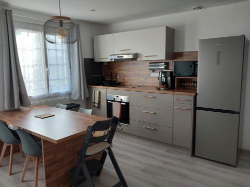 une cuisine avec une table en bois et un réfrigérateur dans l'établissement Petite maison, à Villereau