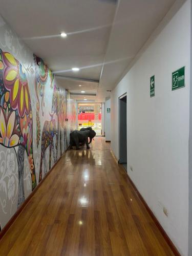 a dog sitting in a hallway with a painting on the wall at Gran Hotel Victoria in Tacna
