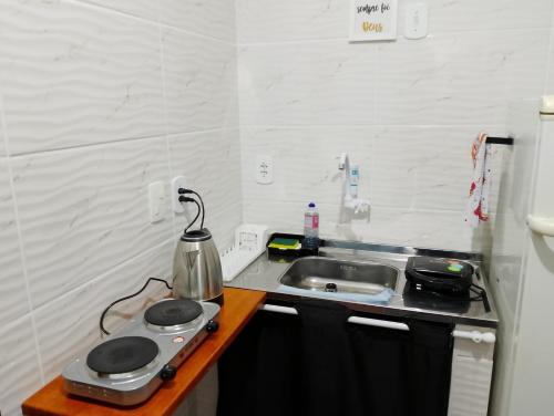 a small kitchen with a sink and a stove at Casa em condomínio Praia Seca in Araruama