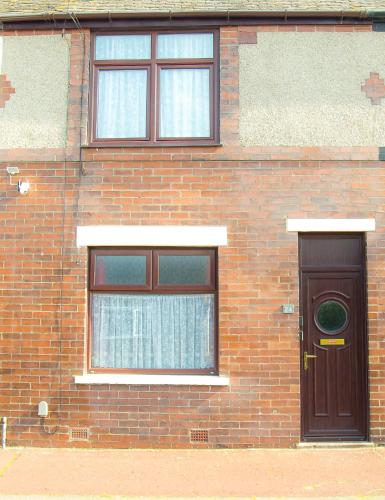 a brick building with a door and two windows at Lucky Home 24 - Ideal for Trade & Family - 2 Bedrooms - 3 Beds - Max 4 Guests - Close to BAE, Docks, Lake District, Beaches in Barrow in Furness