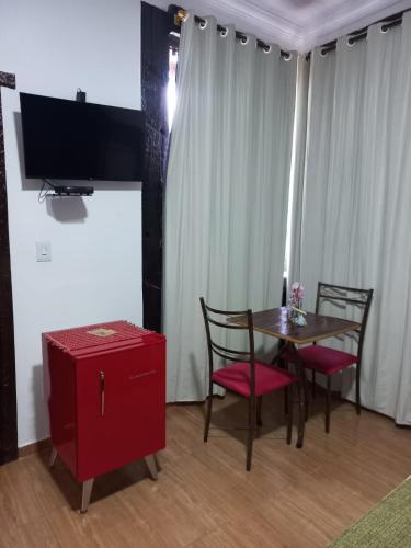 a dining room with a table and chairs and a tv at Pousada Cachoeiras do Cipó in Serra do Cipo