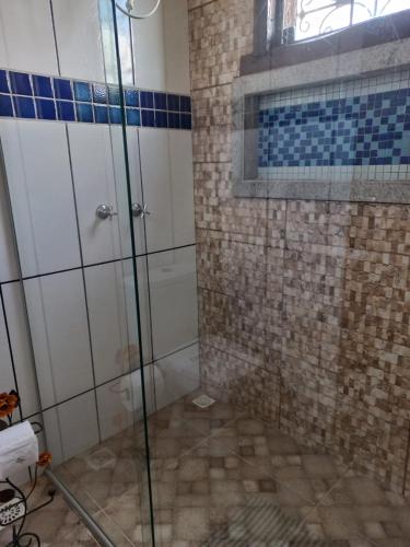 a shower with a glass door in a bathroom at Pousada Cachoeiras do Cipó in Serra do Cipo
