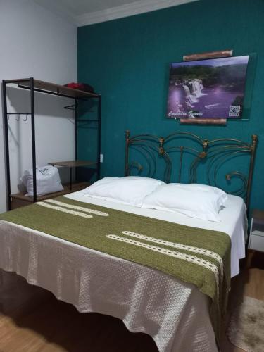 a bedroom with a large bed with a green wall at Pousada Cachoeiras do Cipó in Serra do Cipo
