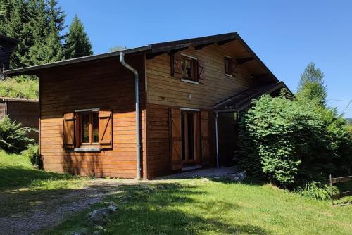 Cette petite maison en bois dispose d'une fenêtre et d'une porte. dans l'établissement Chalet de la Lette, à Ventron