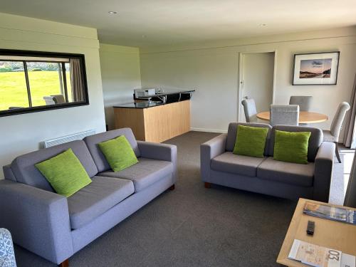 a living room with two couches and a table at Edgewater Hotel in Wanaka