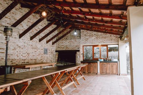 a kitchen with wooden tables and a brick wall at El Colonial Departamentos in Cafayate