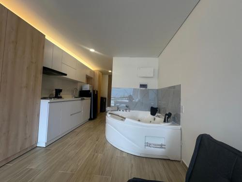 a large white kitchen with a tub in a room at Apartaestudio con Jacuzzi privado y vista a las montanas! in Chía
