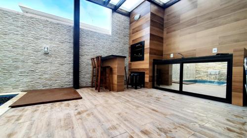 a large room with a fireplace and a brick wall at Linda casa 3 Praia Ponta do Papagaio 190mt mar in Palhoça