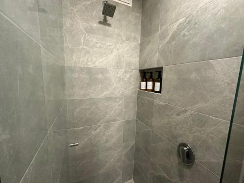 a bathroom with a shower with gray tiles at Apartaestudio con Jacuzzi privado y vista a las montanas! in Chía