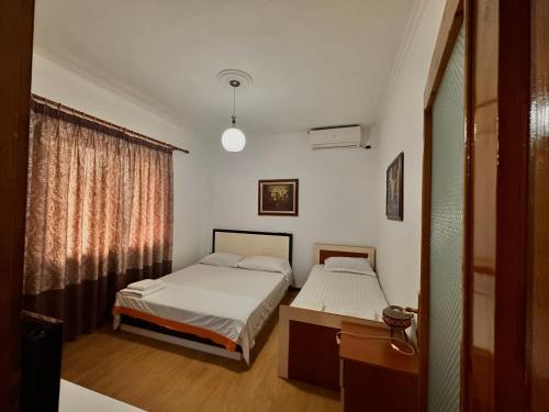 a bedroom with two beds and a window at Grand House Rooms in Tirana