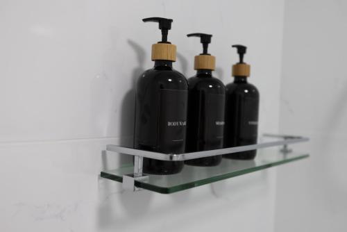 four bottles of wine on a shelf on a wall at Aqua on the Edge in Airlie Beach