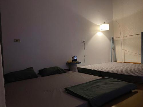 a bedroom with two beds and a light on the wall at cúc cu homestay 5 in Kiến An