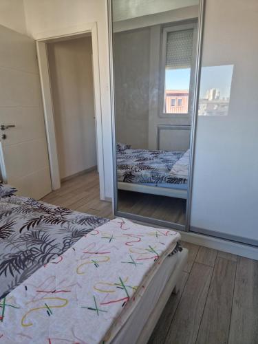 a bedroom with a mirror and a bed in it at Rasadnik Apartment in Skopje