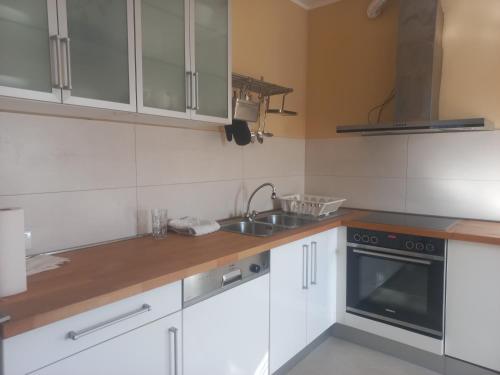 a kitchen with white cabinets and a sink at Smart Stay Odžaci in Odžaci