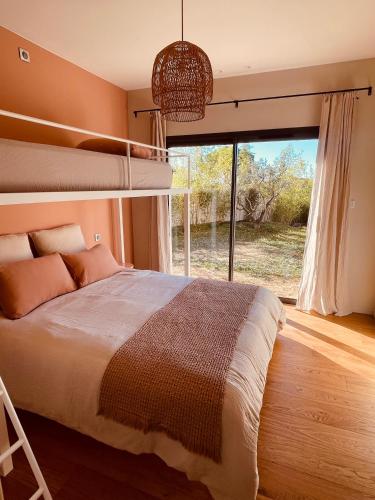 une chambre avec un lit superposé et une grande fenêtre dans l'établissement Villa paisible entre Avignon et Nimes avec piscine chauffée sur demande, à Rochefort-du-Gard