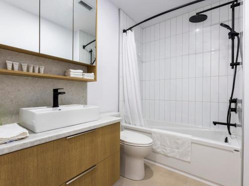 a bathroom with a sink and a toilet and a tub at Lofts Orizon in Rimouski