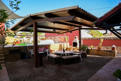 a patio with a table and chairs under a pavilion at Casa Rural LA ENCINA in Hornachuelos
