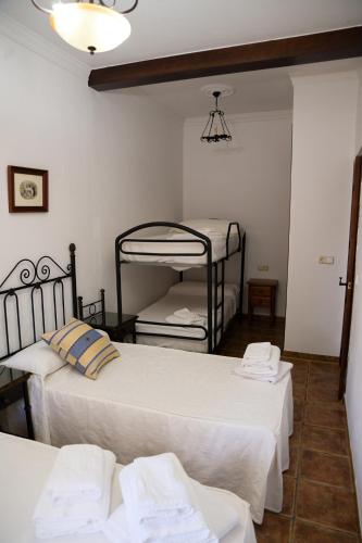 two beds in a room with two bunk beds at Casa Rural LA ENCINA in Hornachuelos