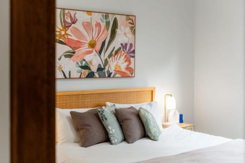 a bedroom with a bed with pillows and a painting at Charming 4 Bed Home in Mount Victoria in Mount Victoria