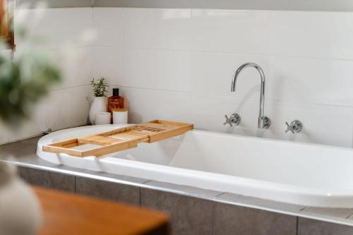 a white bath tub with a wooden cutting board on it at Charming 4 Bed Home in Mount Victoria in Mount Victoria