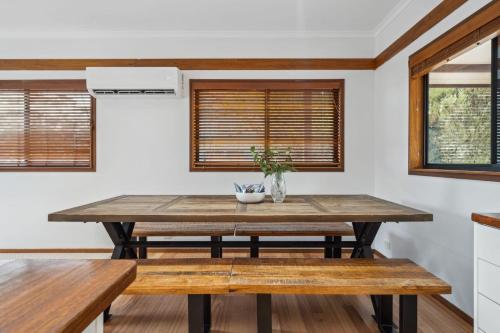 a dining room with a wooden table and benches at Charming 4 Bed Home in Mount Victoria in Mount Victoria