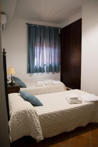 two twin beds in a room with a window at Casa Rural LA ENCINA in Hornachuelos