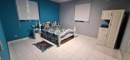 a childs bedroom with a bed and blue walls at Anse Maurice Évasion in Petit-Canal