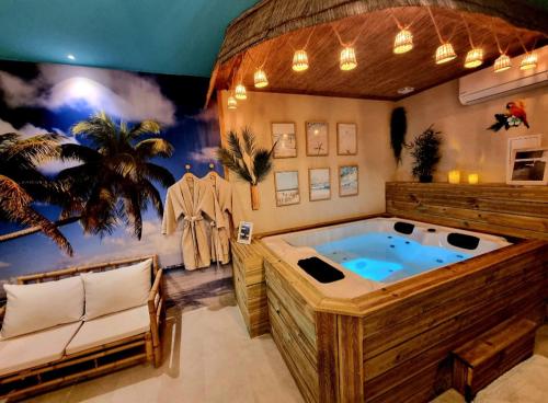a jacuzzi tub in the middle of a room at Les Spas de la Mer, Appart&Spa Aloha, 100m de la plage, Plein cœur du Grau in Le Grau-du-Roi