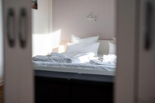 a bed with white sheets and pillows is seen through a mirror at Ferienhaus-Hus-Stine-an-der-Mueritz in Rechlin