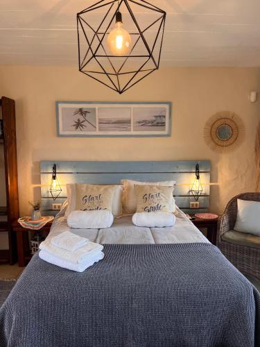 a bedroom with a bed with two pillows on it at Los Pecados de la Viuda in Punta Del Diablo