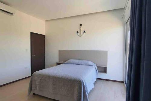 a white bedroom with a bed and a window at Almendros in El Conacaste