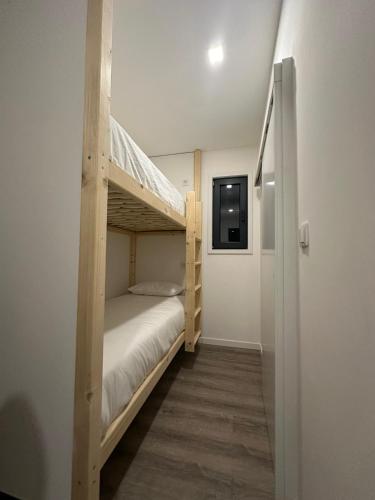 a bedroom with a bunk bed with a ladder at Trendy Villas Hostel in Vila Chã