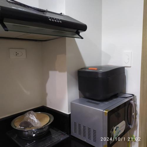 a microwave with a bowl of food on top of it at Staycation by Estelle in Manila
