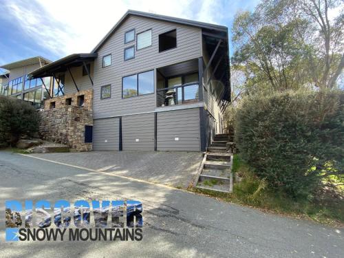 a large house with a garage on a street at Ramshead Creek 3 - Thredbo in Thredbo