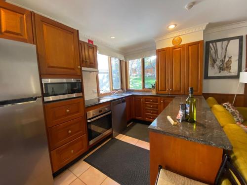 a kitchen with wooden cabinets and a yellow couch at Bollygums - Thredbo in Thredbo