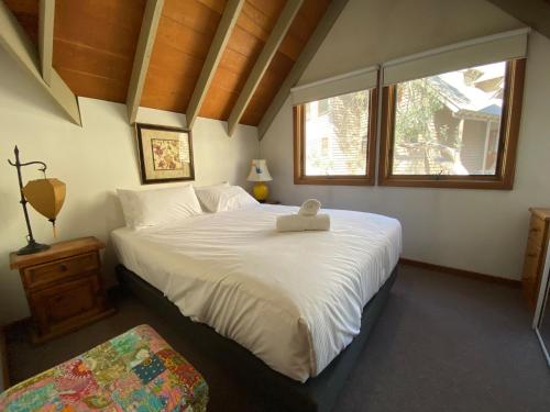 a bedroom with a large bed with a stuffed animal on it at Bollygums - Thredbo in Thredbo