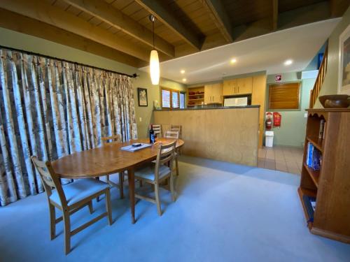 a dining room with a wooden table and chairs at Mitta Mitta - Thredbo in Thredbo