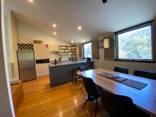a kitchen and dining room with a large wooden table at Oberdere 3 - Thredbo in Thredbo