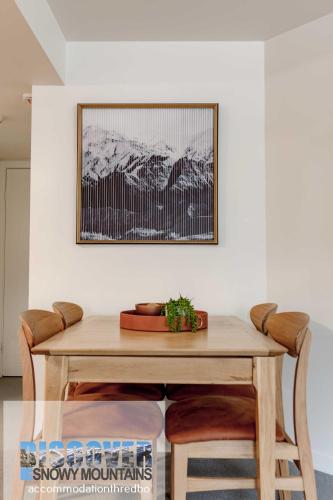 a dining room table with a picture on the wall at Wintergreen 3 - Thredbo in Thredbo