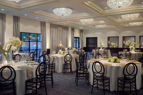 a banquet room with white tables and chairs and chandeliers at Charlotte Marriott SouthPark in Charlotte