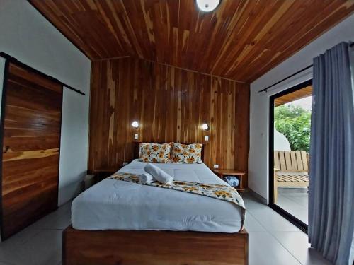a bedroom with a large bed with a wooden ceiling at Belcruz family lodge in Monteverde Costa Rica