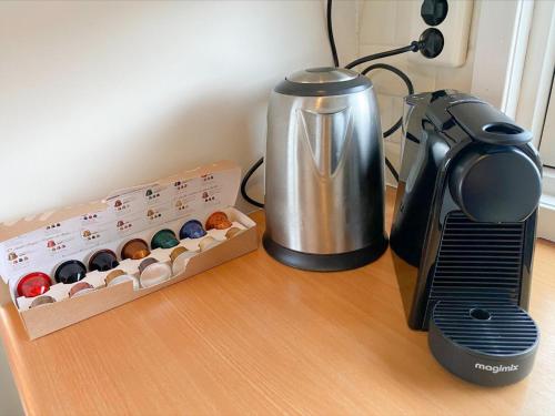 a counter with a coffee maker next to a box of muffins at Blauwborst 24-18 in Nieuwersluis