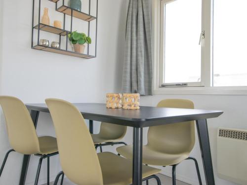 a dining room table with yellow chairs around it at Blauwborst 24-18 in Nieuwersluis