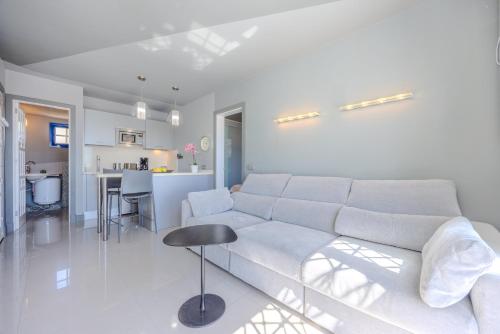 a white living room with a couch and a table at Atalaya 2 Sea View - Puerto del Carmen in Tías