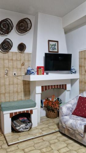 a living room with a tv and a fireplace at Casa Macedo in Alfândega da Fé
